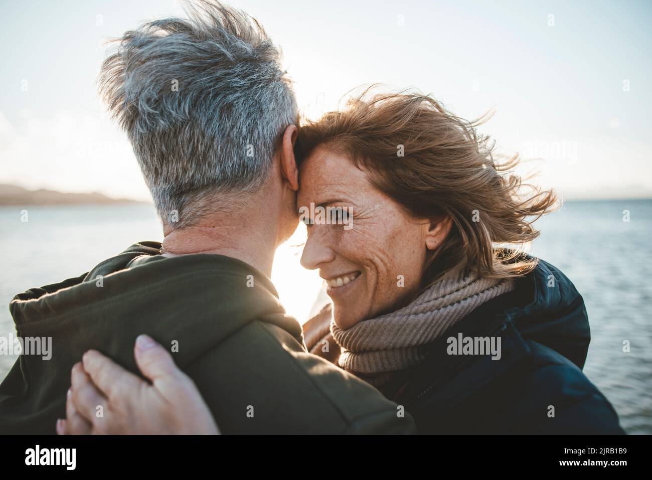 Coppia matura felice abbracciandosi a vicenda in spiaggia Foto Stock