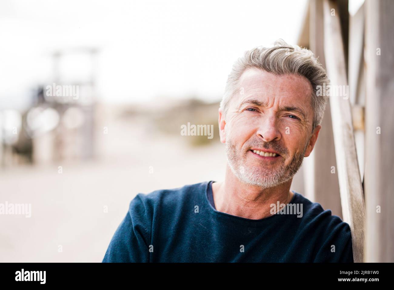 Felice uomo maturo con capelli grigi in spiaggia Foto Stock