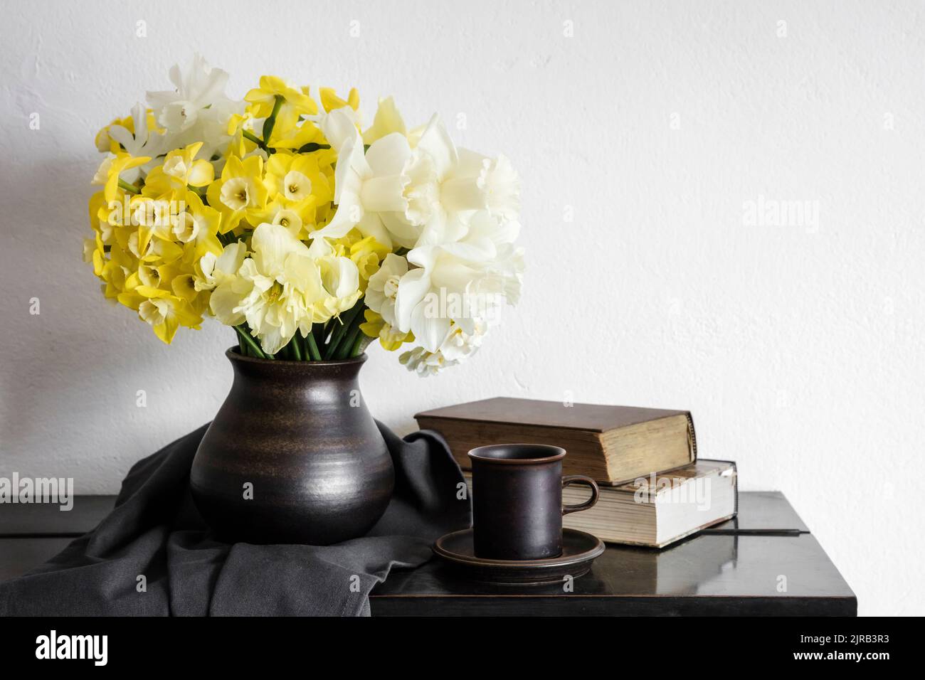 Studio shot di vaso con daffodils fiorente in piedi su un tavolo rustico Foto Stock