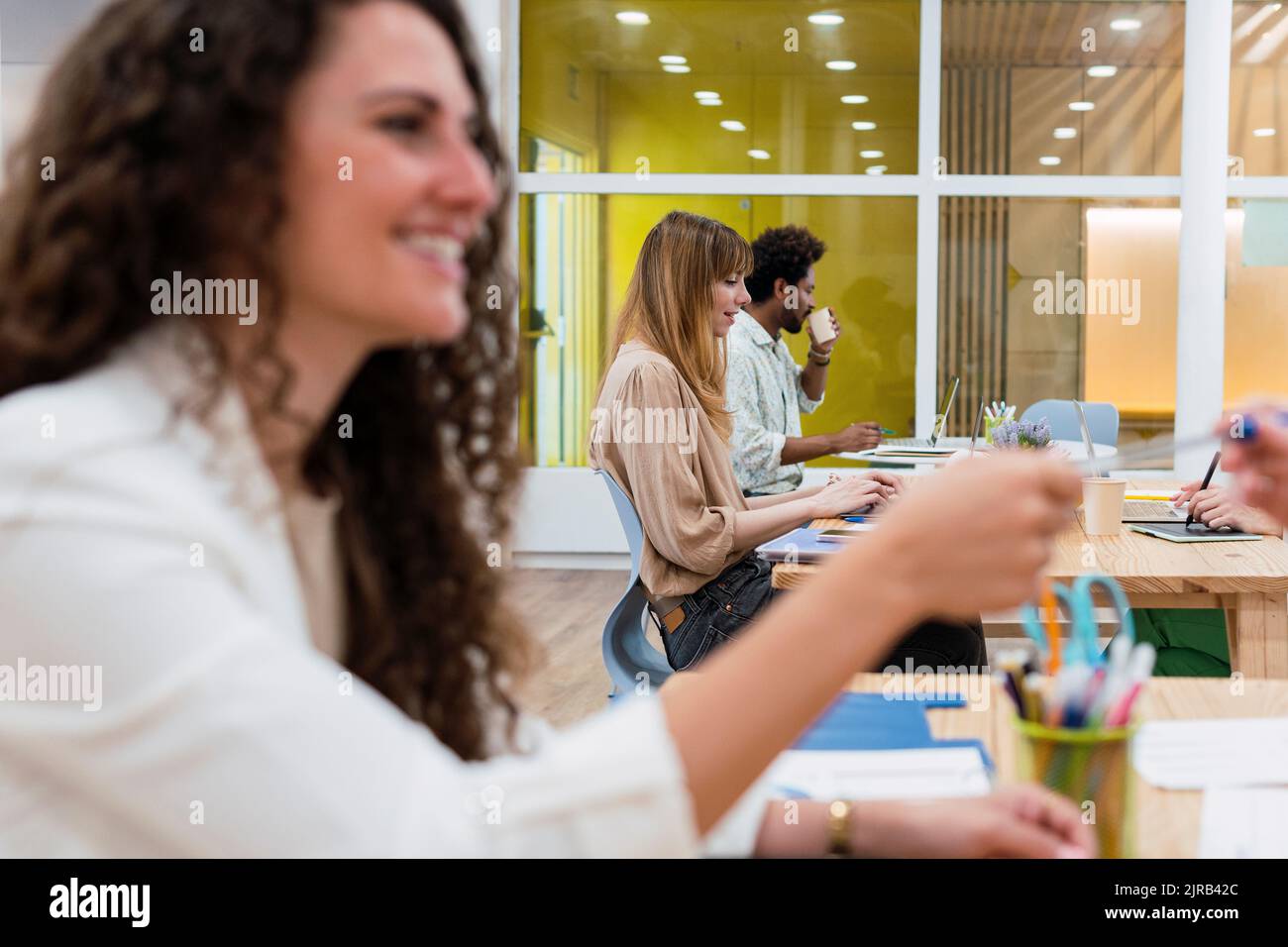 Donna d'affari che consegna la penna a un collega in ufficio Foto Stock