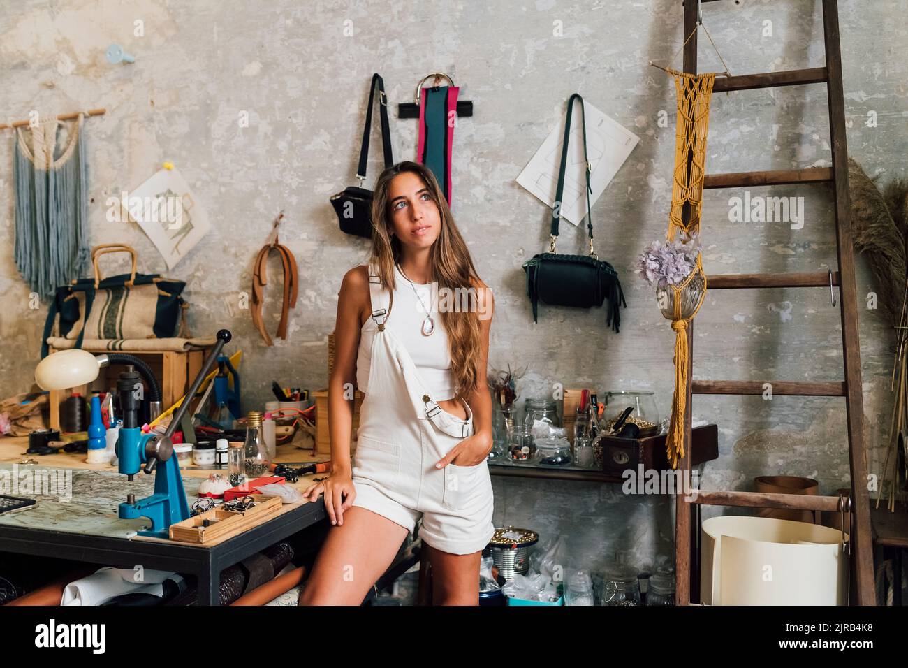 Designer di moda attento in piedi con mano in tasca in officina Foto Stock