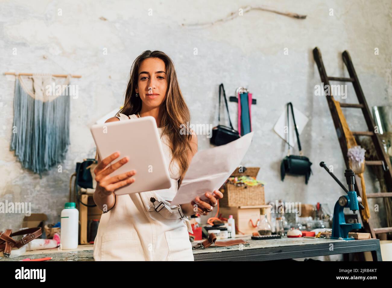 Carta da studio stilista che guarda il tablet PC Foto Stock