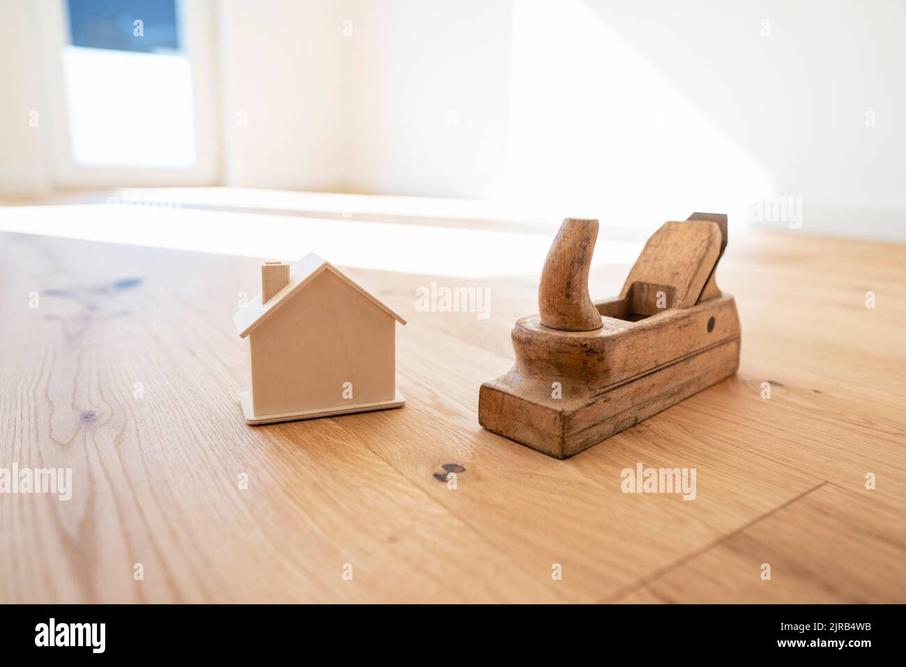 Casa modello tenuta da attrezzature su pavimento in legno duro Foto Stock