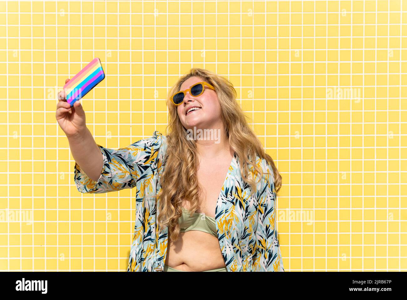 Donna sorridente più grande che prende selfie attraverso il telefono cellulare Foto Stock