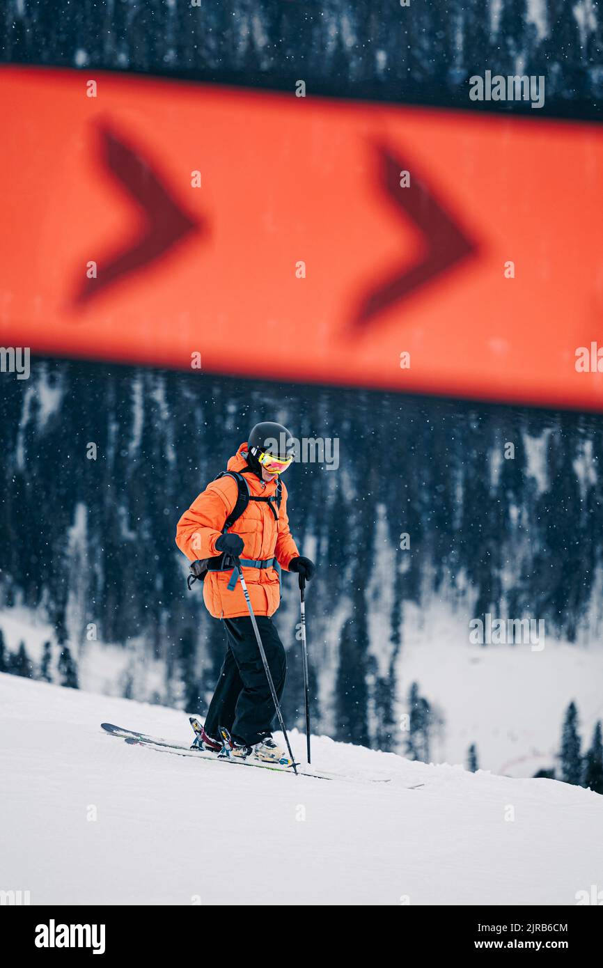 Uomo con ski-pole che cammina sulla neve Foto Stock