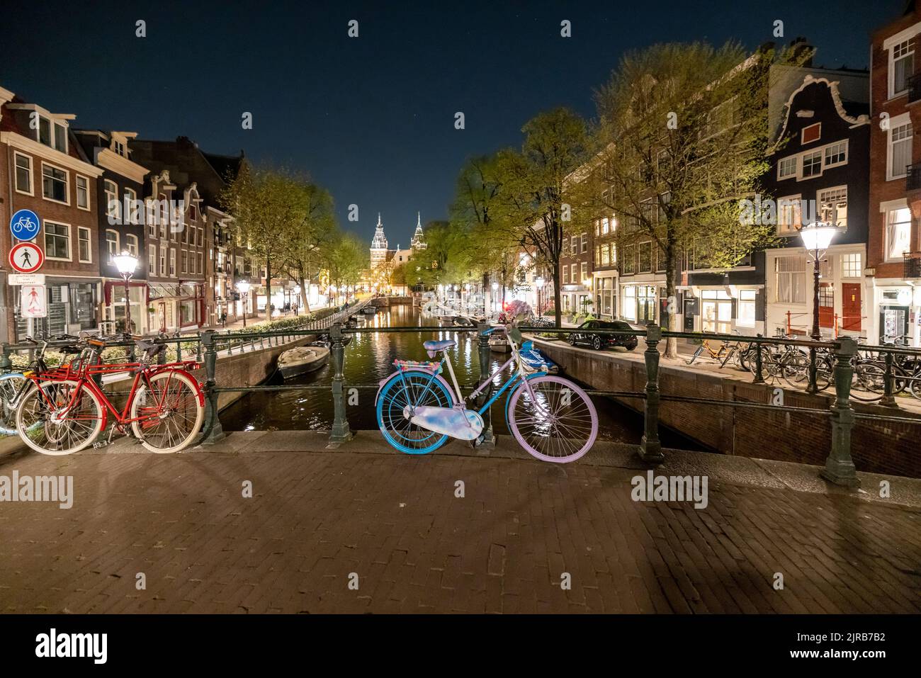 Paesi Bassi, Olanda del Nord, Amsterdam, biciclette a sinistra lungo il ponte sul canale di notte Foto Stock