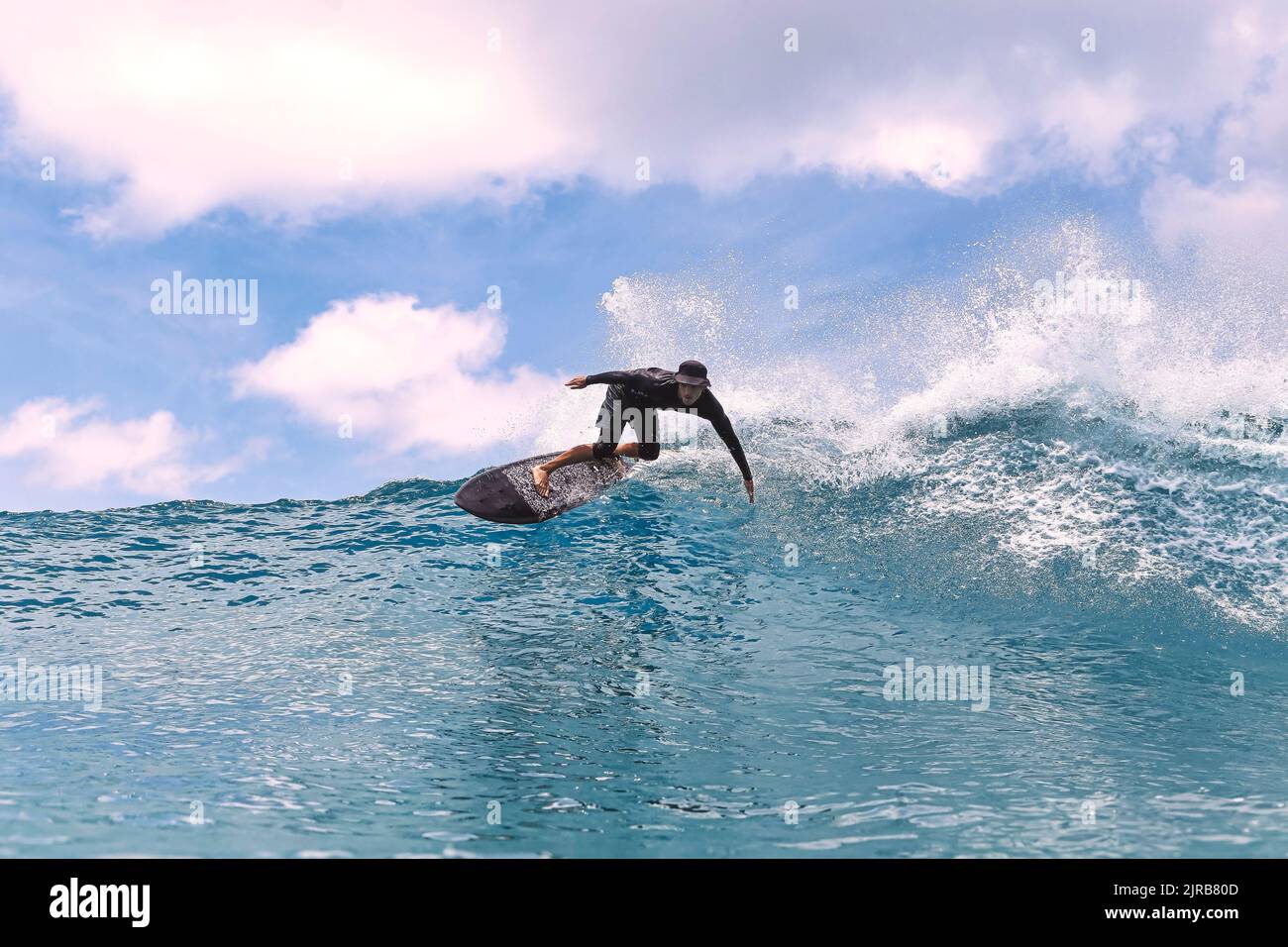 Uomo con surf in mare in vacanza Foto Stock
