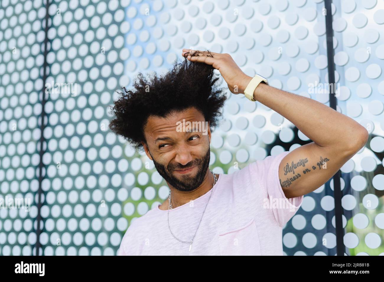 Uomo con mano nei capelli che fanno il viso Foto Stock