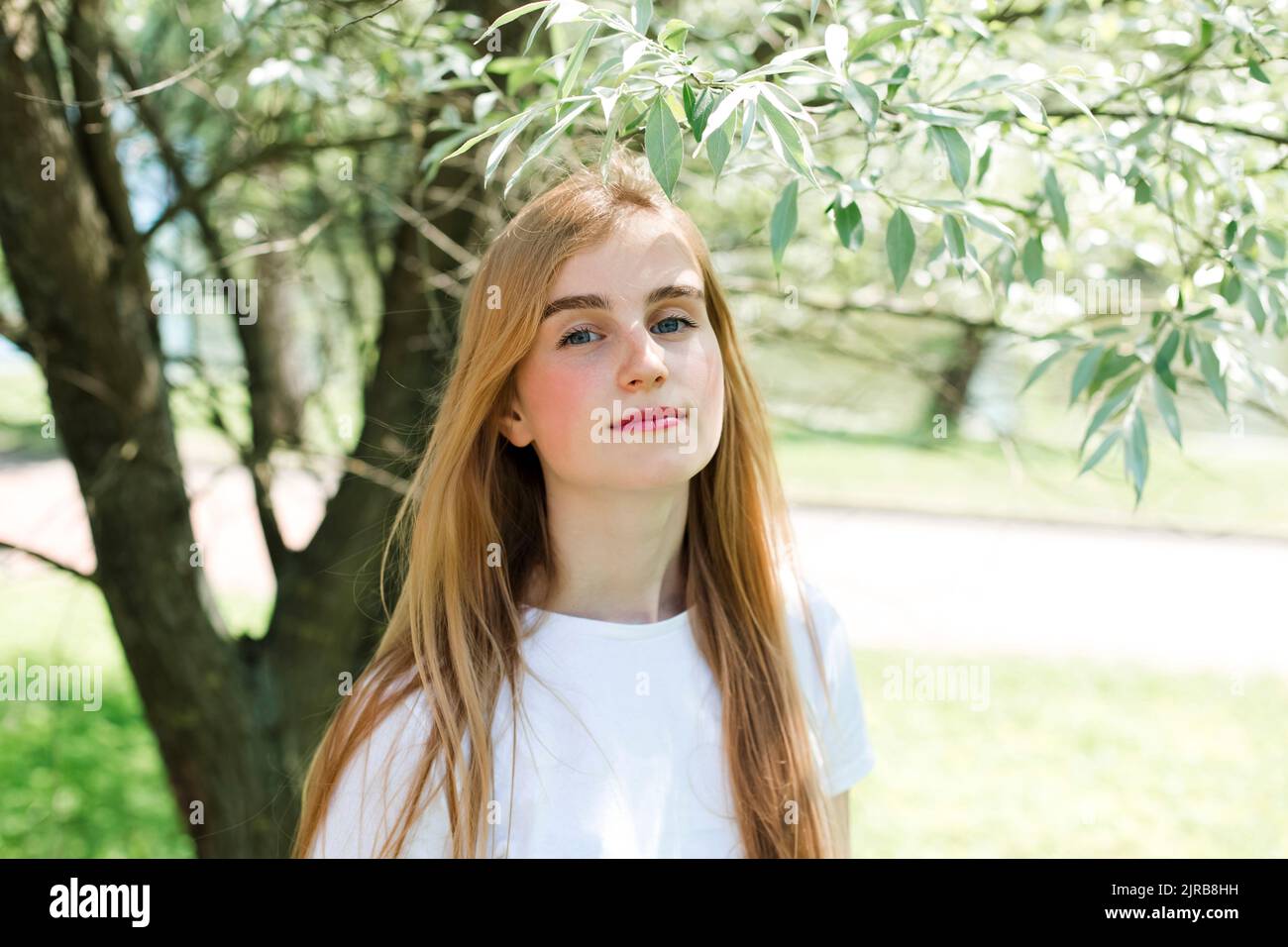 Ragazza adolescente con capelli biondi nel parco Foto Stock