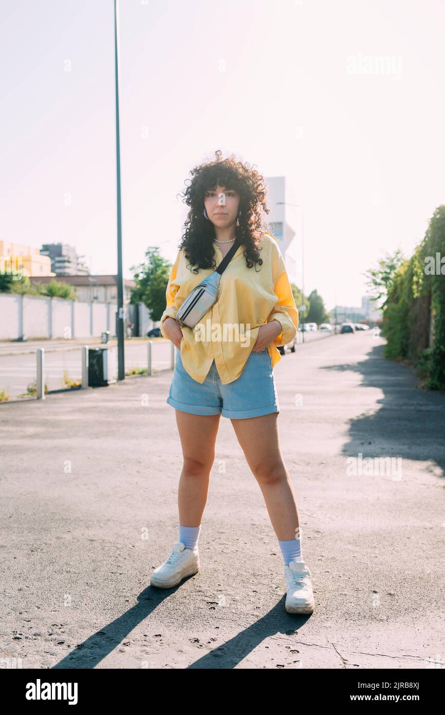 Donna di fiducia con le mani in tasca in piedi sulla strada Foto Stock
