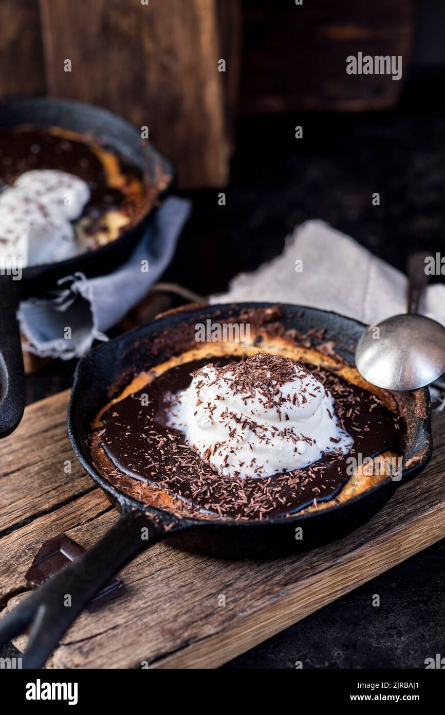 Padella con biscotti al cioccolato ricoperti di ganache e panna montata Foto Stock