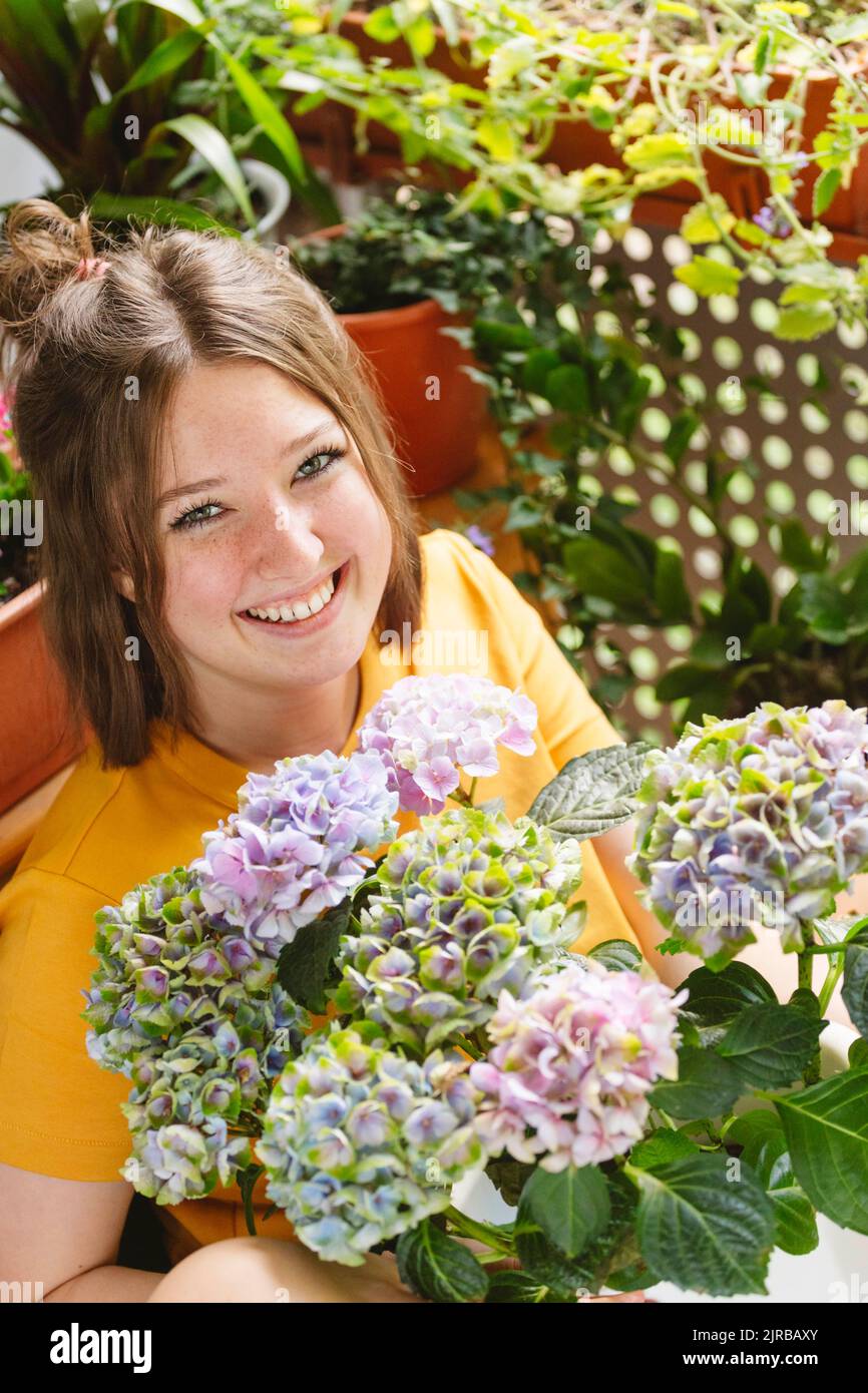 una donna di 60 anni in giardino. Una donna matura gode dei fiori di un  ortensia cresciuto con le proprie mani Foto stock - Alamy