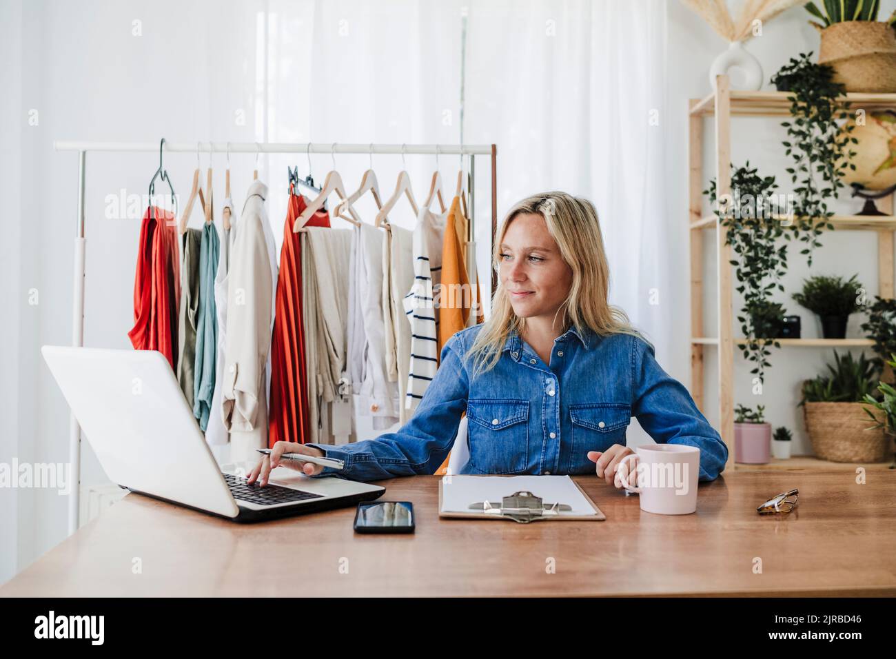 Stilista di moda che lavora su un notebook in ufficio a casa Foto Stock