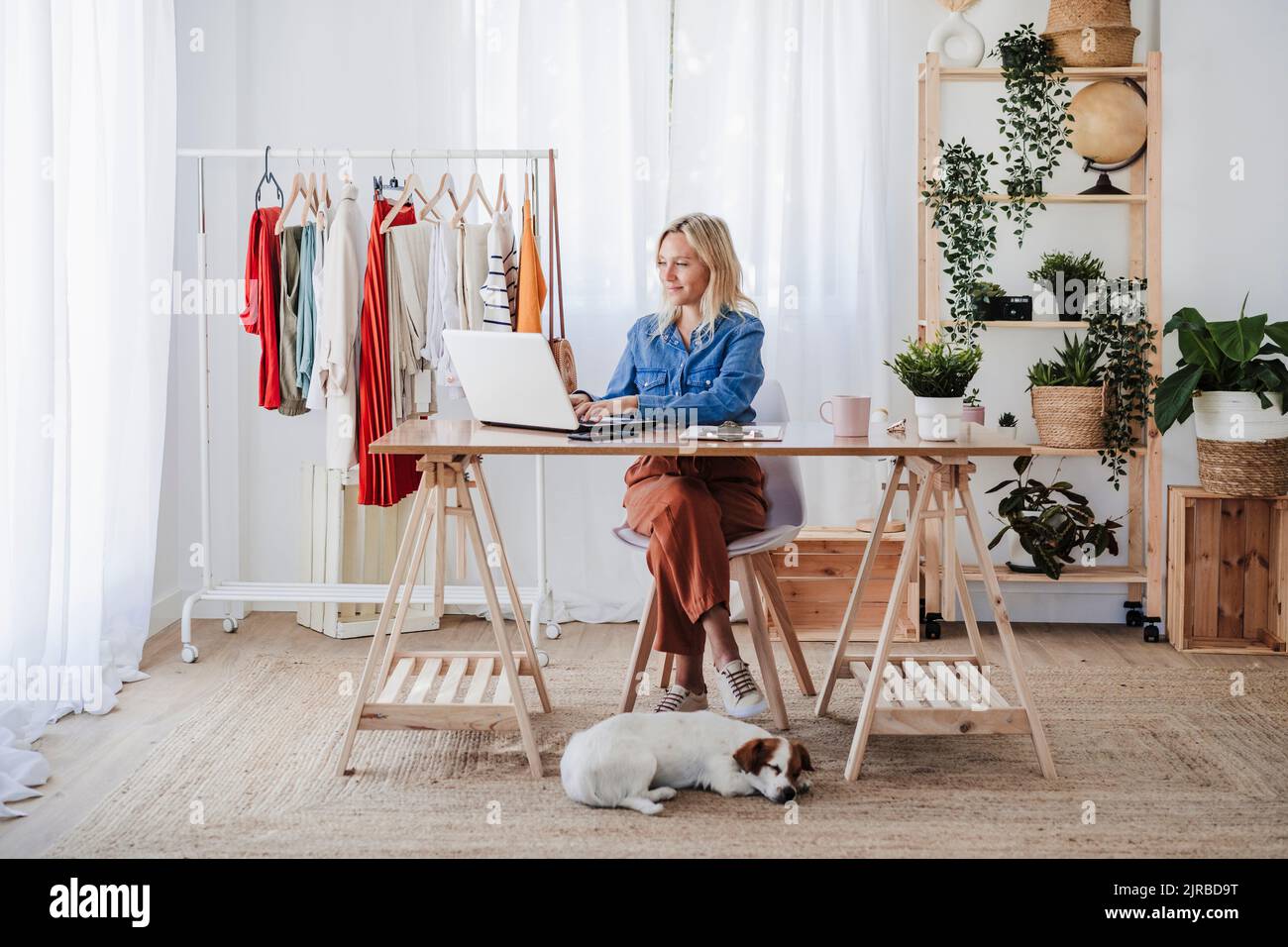 Giovane designer di moda che lavora su un computer portatile in ufficio a casa Foto Stock