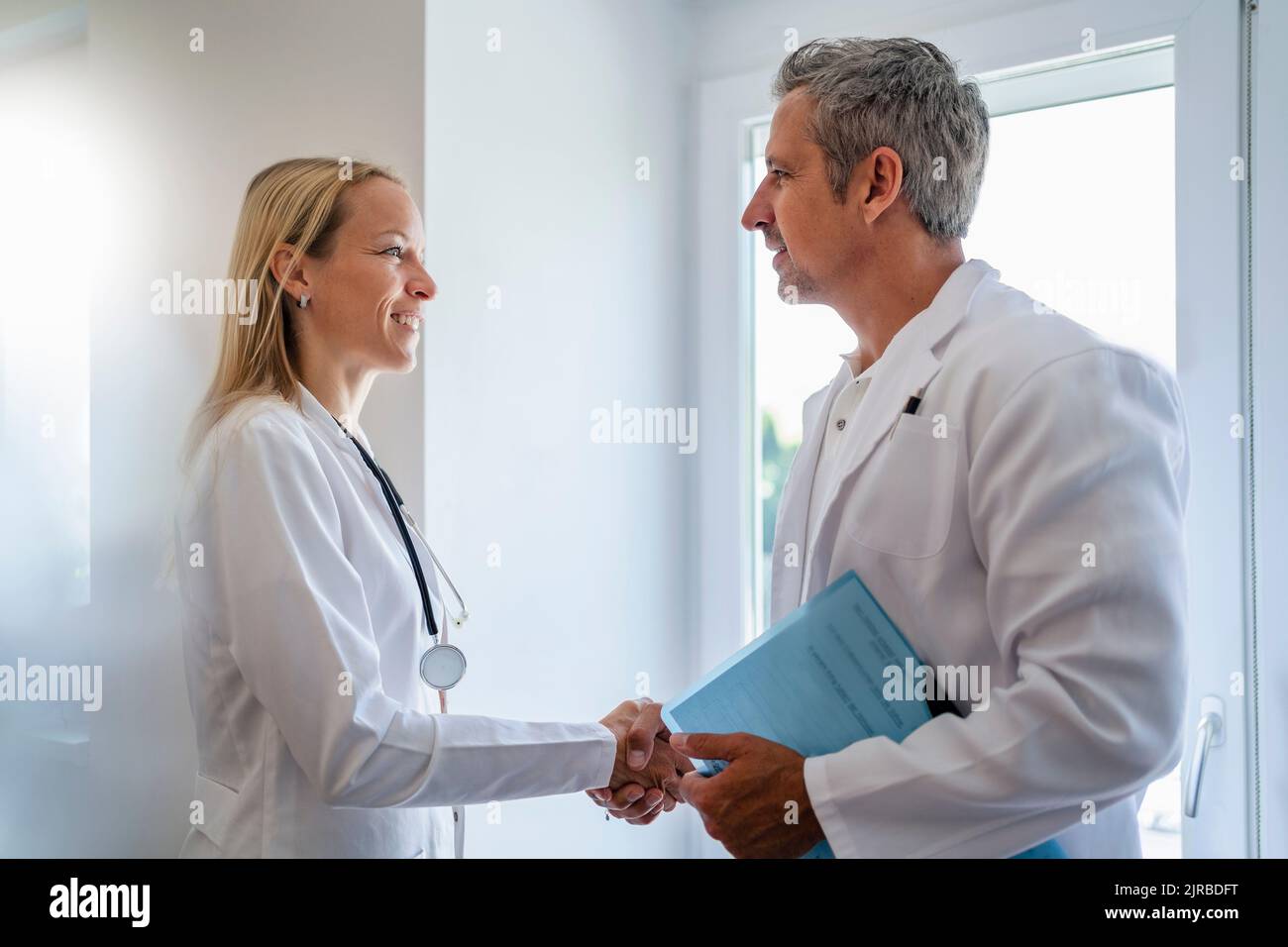 Maschio e femmina medico stringono le mani Foto Stock