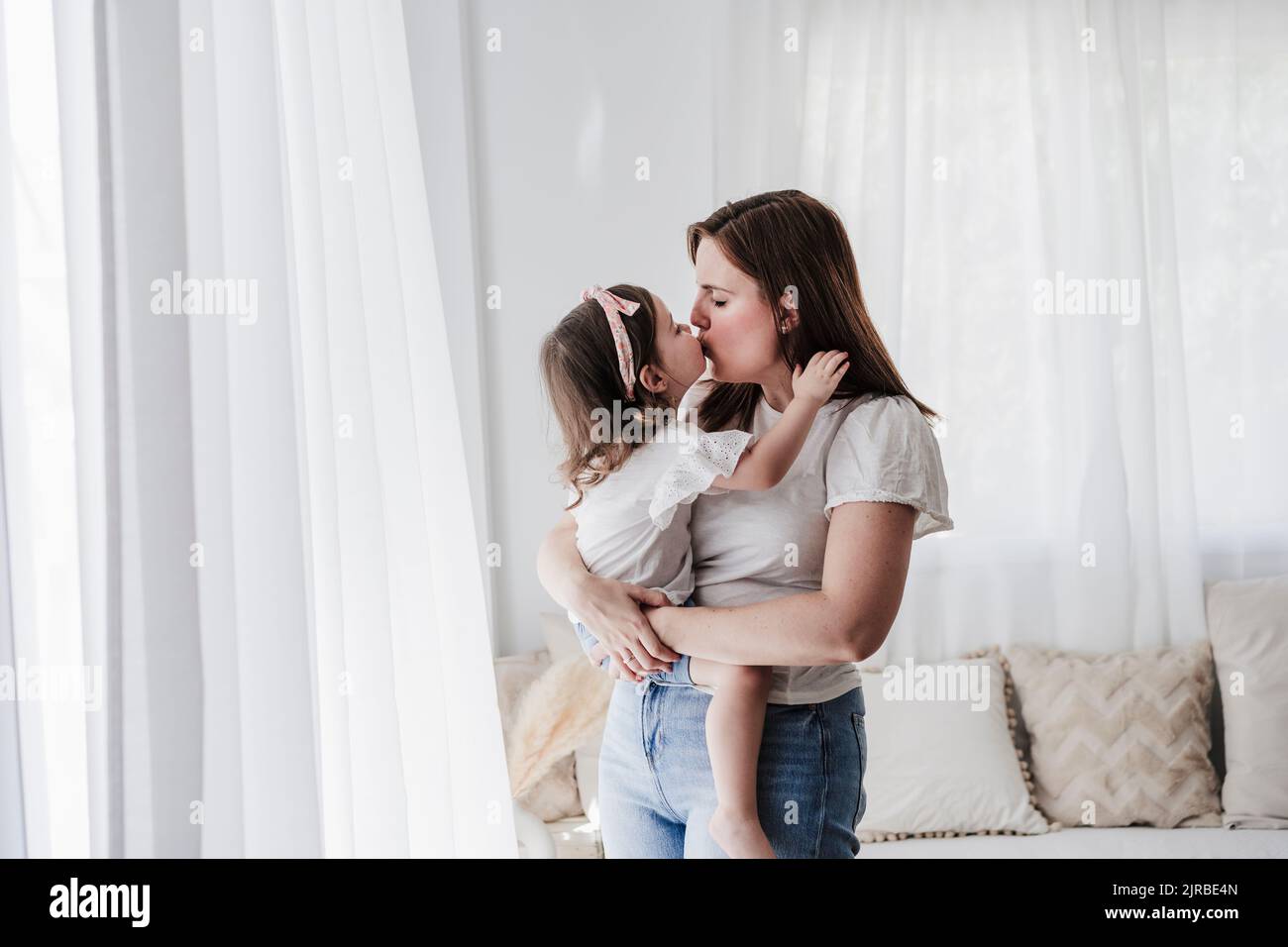Madre e figlia si baciano a casa Foto Stock