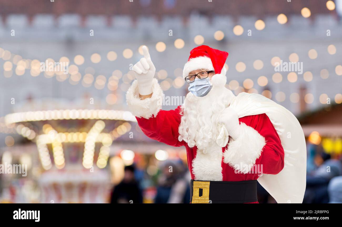 uomo in costume di babbo natale con maschera medica Foto Stock