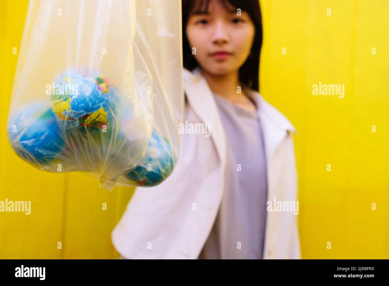 Giovane donna che mostra globi in sacchetto di polietilene Foto Stock