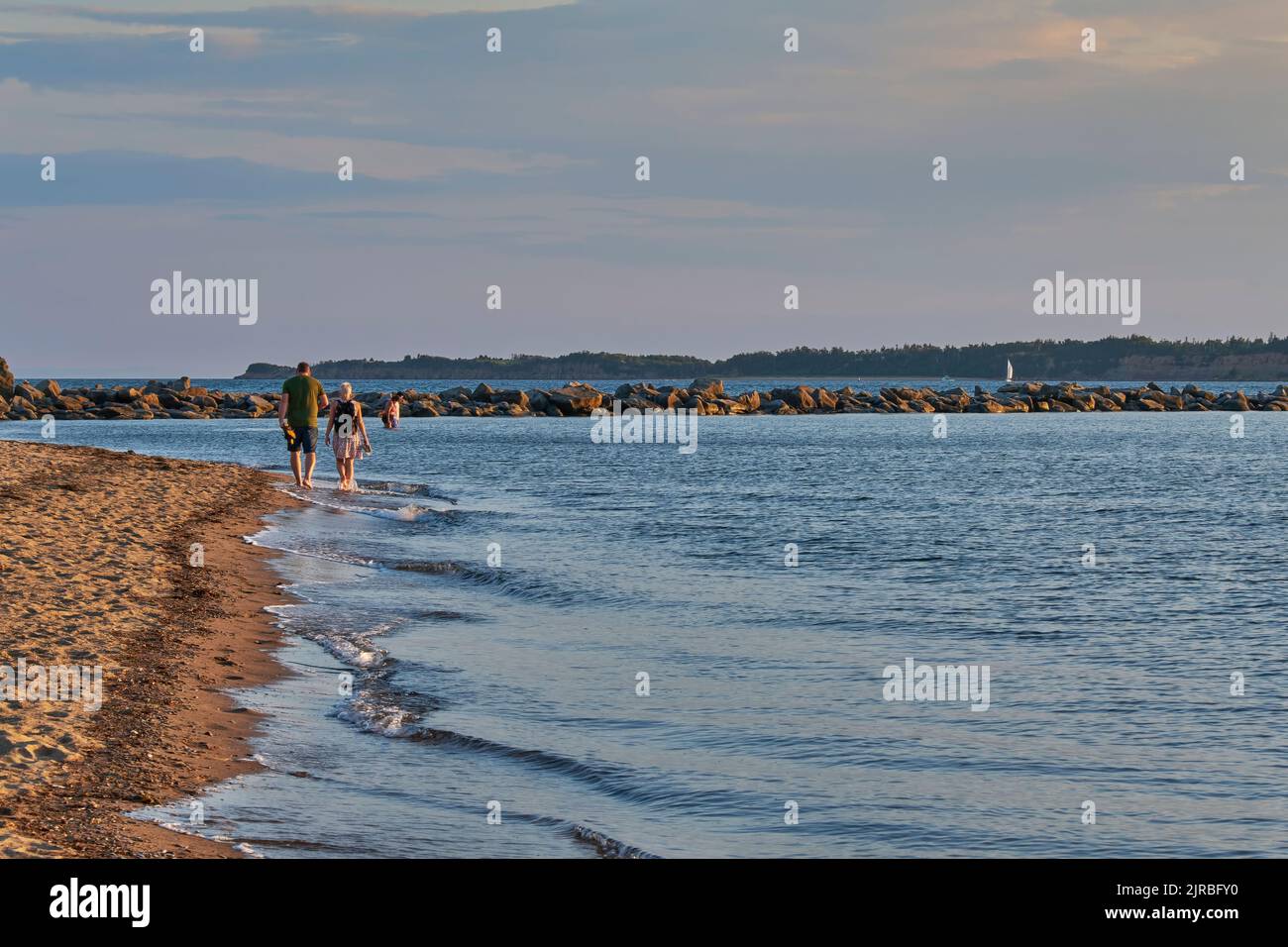 Coppia passeggiando lungo Breakwater Beach a Port Hood Nova Scotia al tramonto in una bella serata estiva. Foto Stock