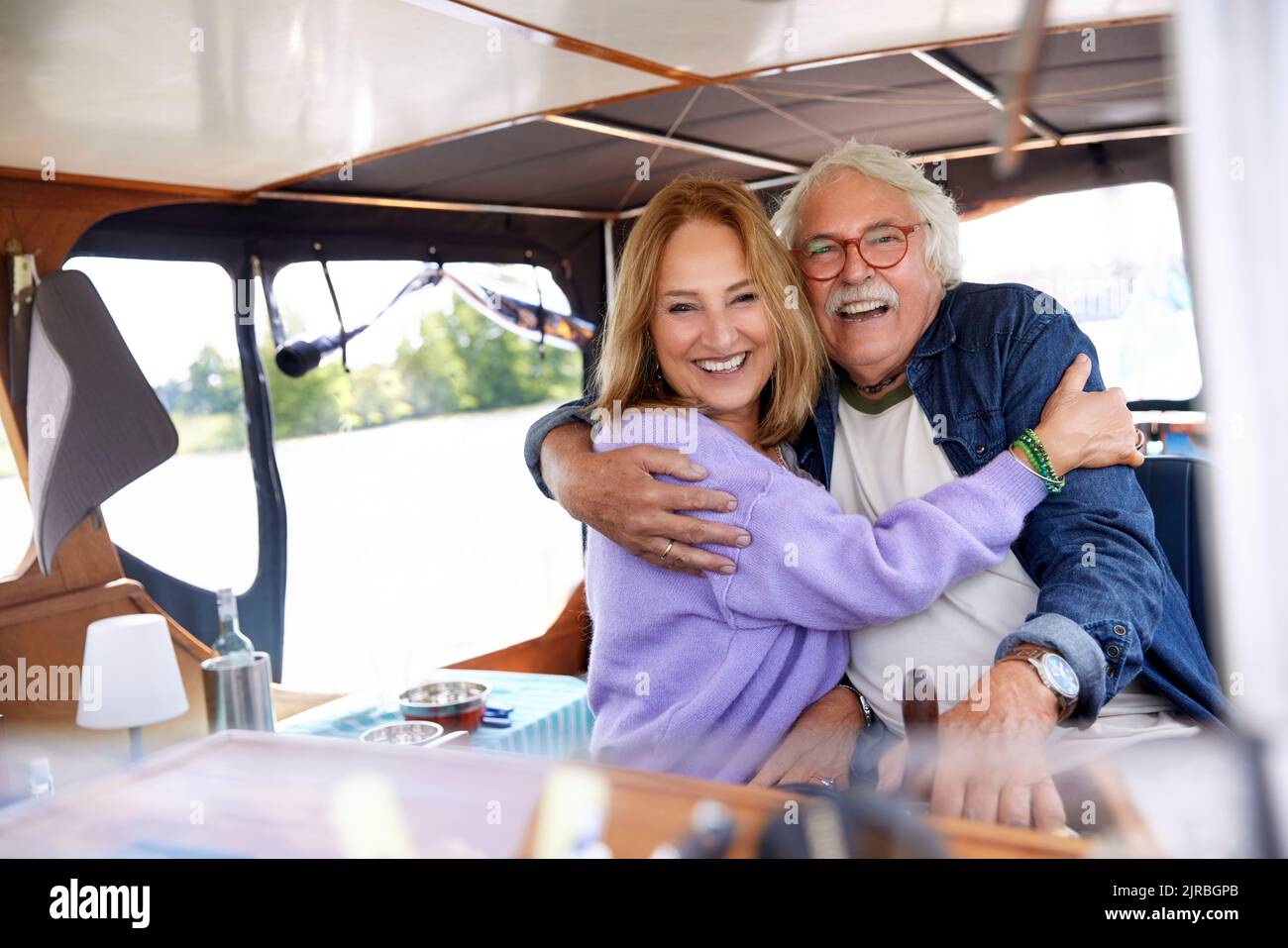 Coppia anziana felice che si abbraccia a vicenda in barca Foto Stock