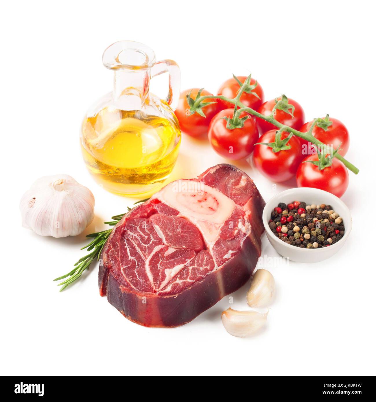 bistecca di manzo crudo con osso, spezie, rosmarino e ingredienti da cucina isolati su sfondo bianco. Foto Stock