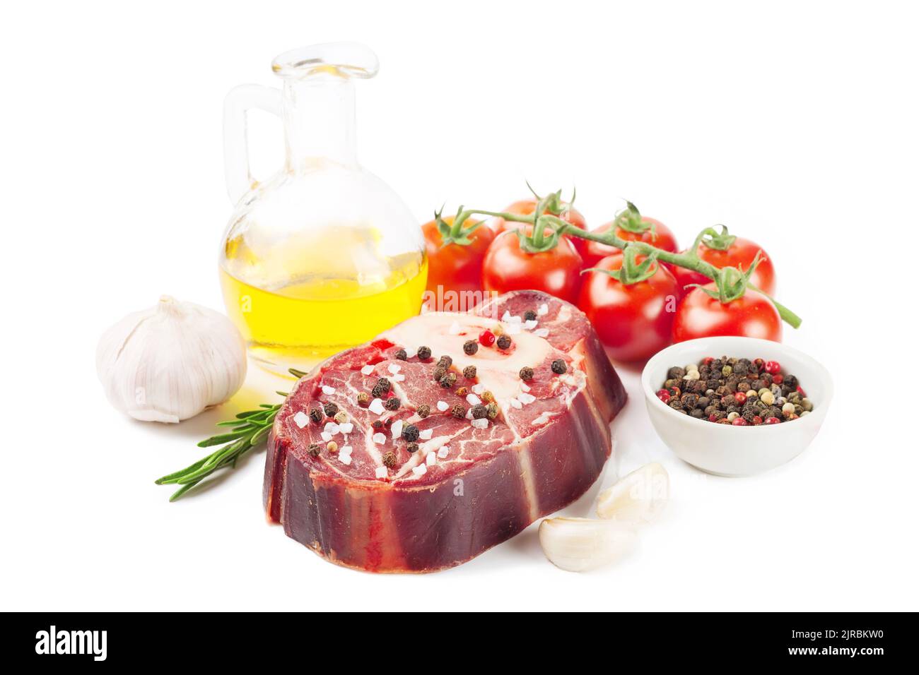 bistecca di manzo crudo con osso, spezie, rosmarino e ingredienti da cucina isolati su sfondo bianco. Foto Stock