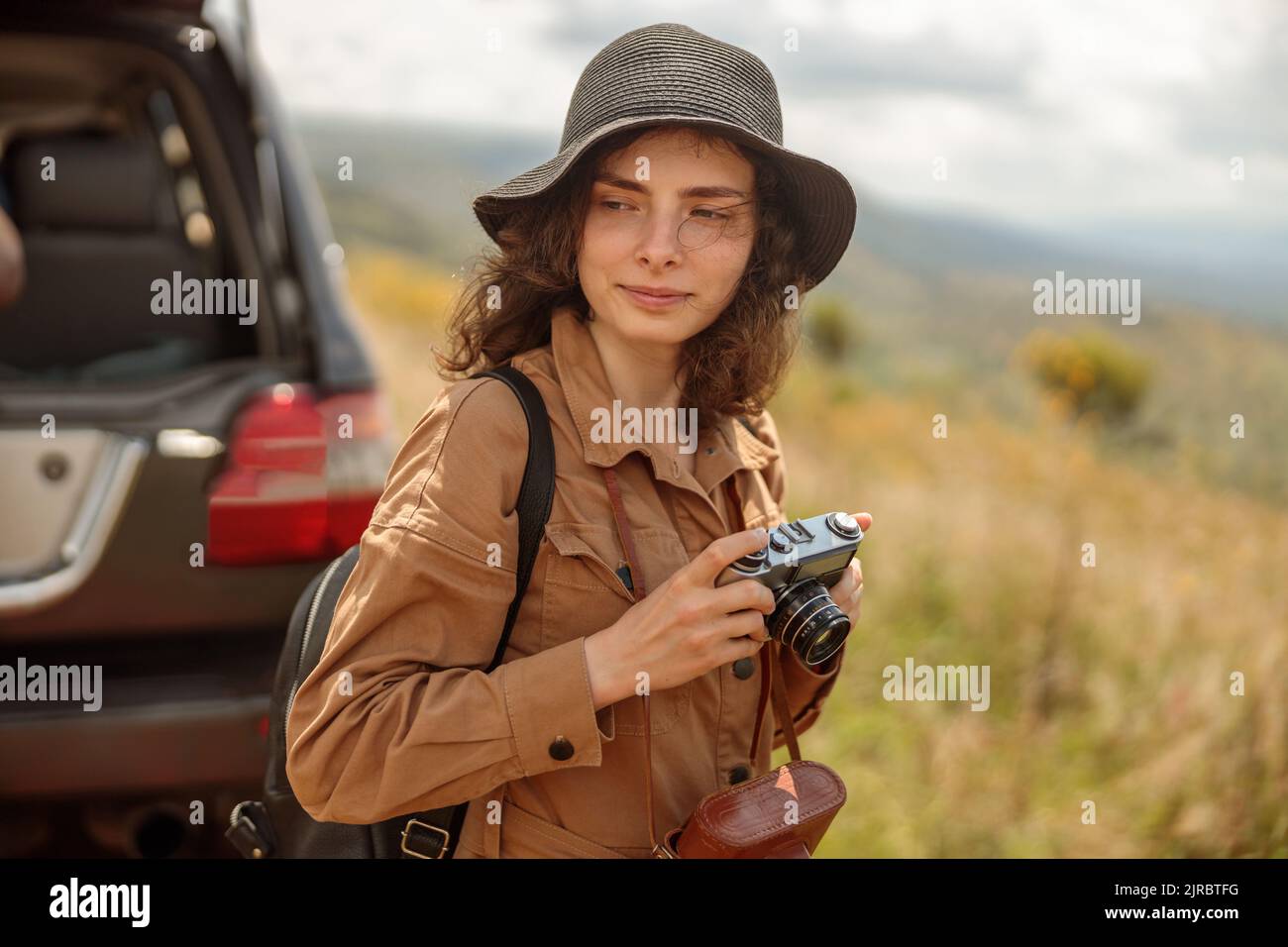 Donna felice che va a scattare foto mentre viaggia attraverso la savana Foto Stock