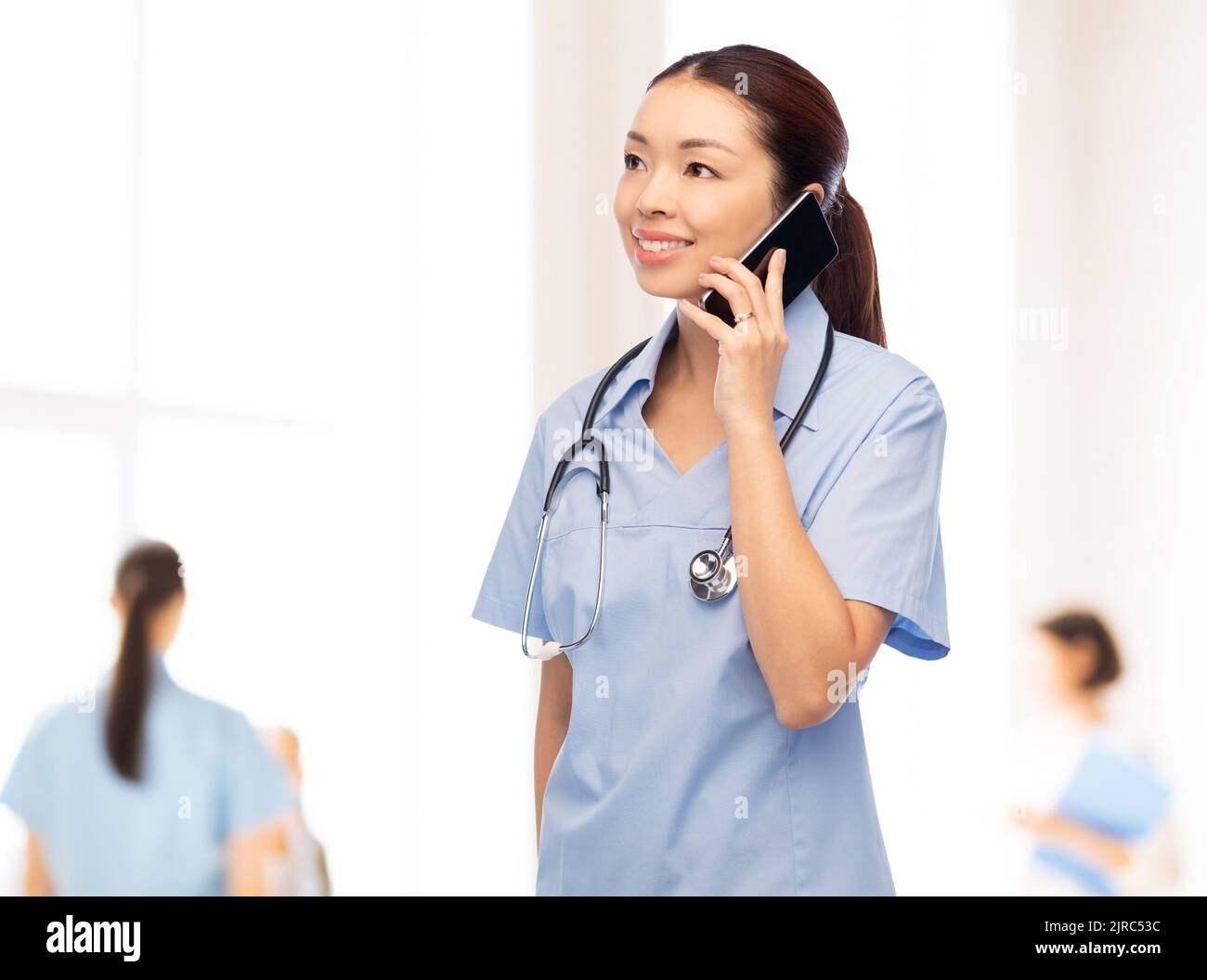 chiamata infermiere asiatica su smartphone presso l'ospedale Foto Stock