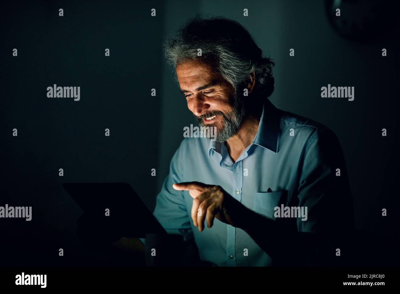uomo d'affari laptop tablet notte business computer uomo anziano anziano vecchio anziano ufficio tecnologia luce lavoro giovane internet scuro ritardo lavoro Foto Stock