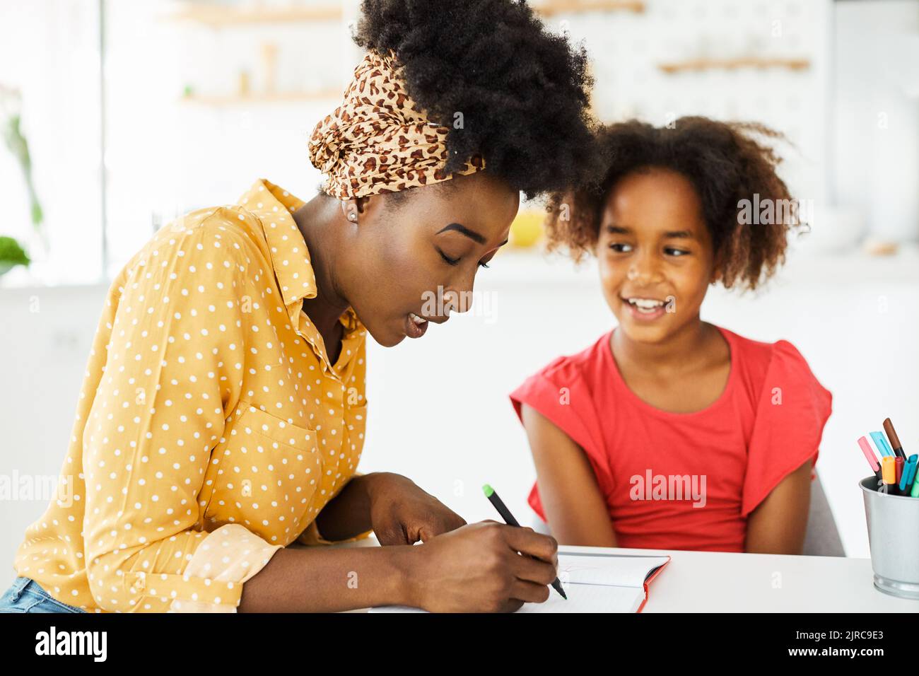 compiti di insegnamento istruzione madre figli figlia familiarità infanzia insegnante classe nero afroamericano Foto Stock