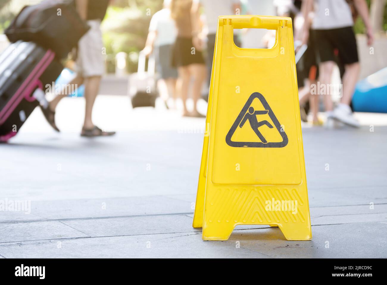 Il cartello giallo di avvertimento sul pavimento bagnato si trova in aeroporto Foto Stock