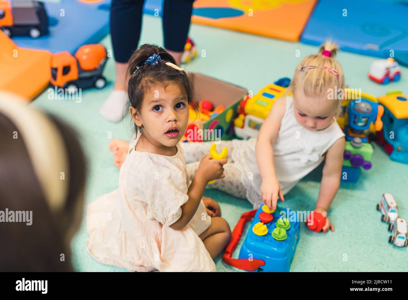 I bambini che giocano con un colorato giocattolo selezionatore a forma di plastica. Lavora sulle capacità di problem-solving, sullo sviluppo delle capacità motorie e motorie grossolane attraverso il gioco sensoriale nella scuola materna. Foto di alta qualità Foto Stock