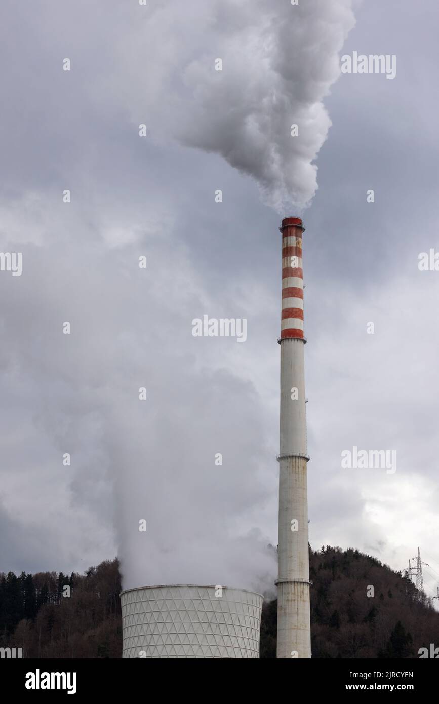 Parte superiore della centrale a carbone camino con fumo bianco, emissioni tossiche, in aumento nel cielo, basso angolo di ripresa. Concetto di inquinamento dell'aria e dell'ambiente. Foto Stock