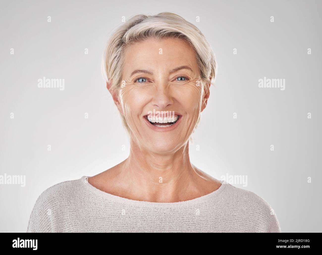 Donna anziana con sorriso per la salute dentale, la cura della pelle di bellezza e il contenuto faccia contro lo studio mockup sfondo. Ritratto di modello felice con sano Foto Stock