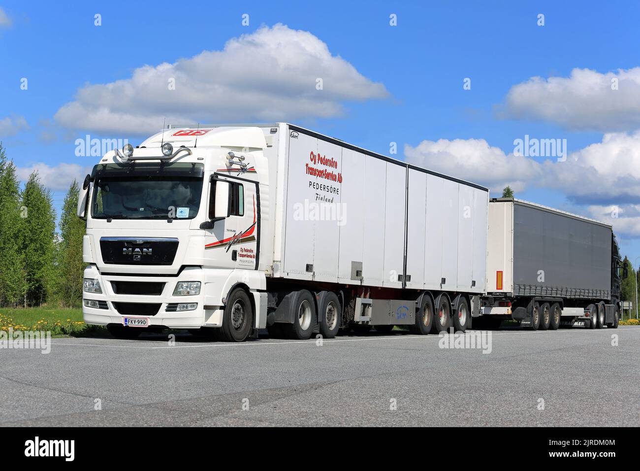 White MAN TGX 26,480 semirimorchio parcheggiato in sosta con un altro semirimorchio in una giornata di sole d'estate. Karkkila, Finlandia. Maggio 2016. Foto Stock