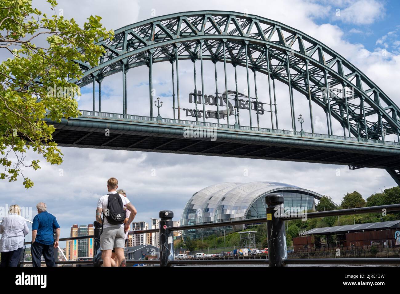 Un gruppo di persone che visitano il Quayside, Newcastle upon Tyne, Regno Unito, sotto il Tyne Bridge. Foto Stock