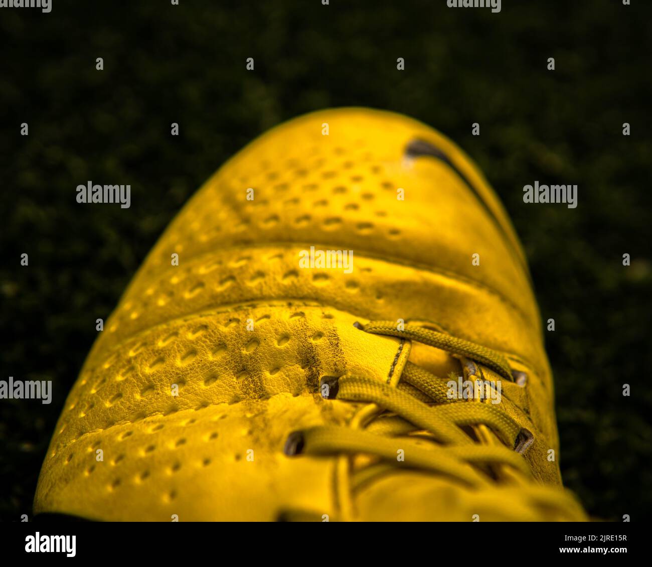 Primo piano di una scarpa da calcio gialla Nike CTR360 Maestri su sfondo nero Foto Stock