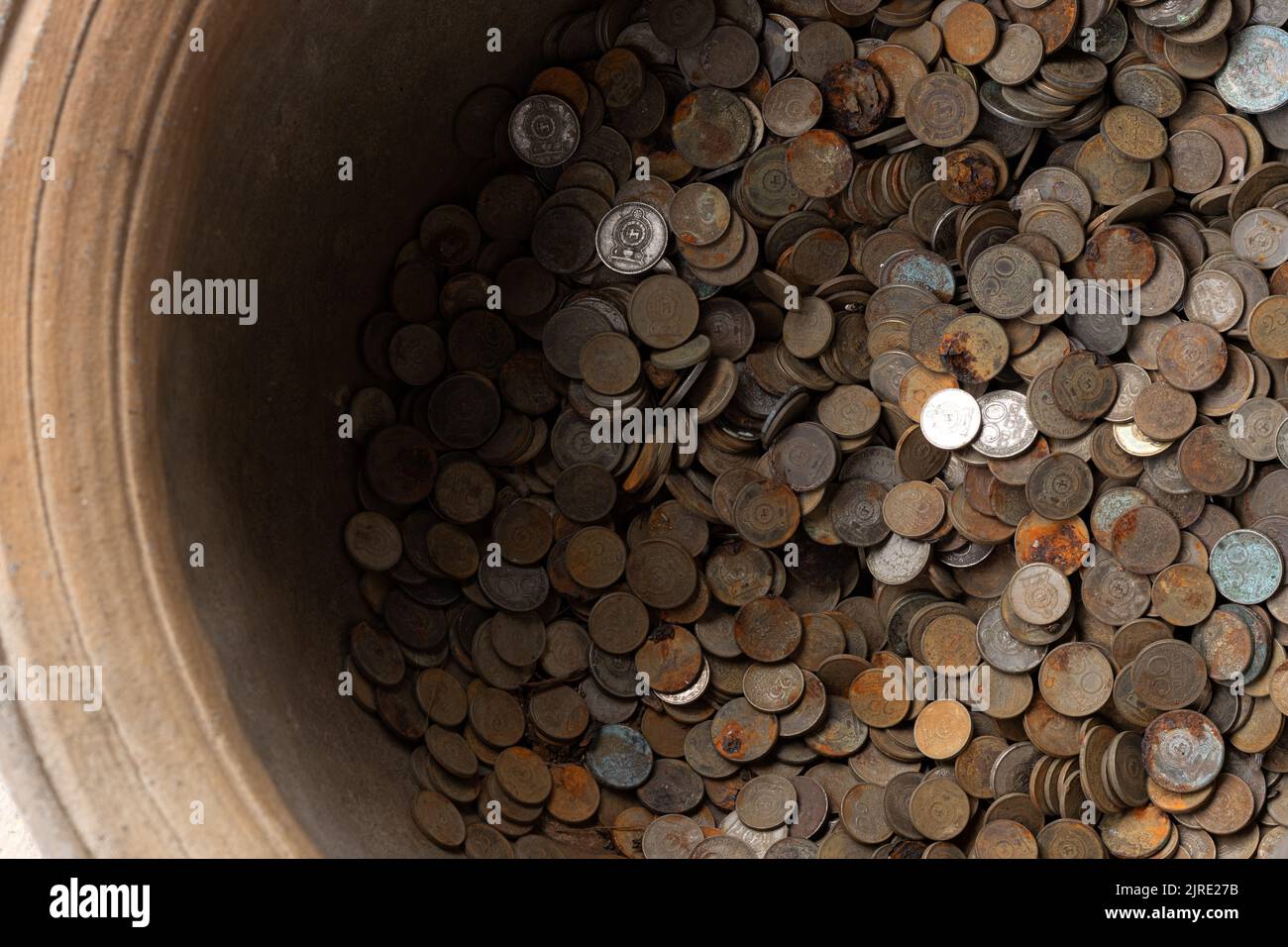 Collezione molto vecchia di vecchie monete arrugginite in un contenitore di metallo Foto Stock