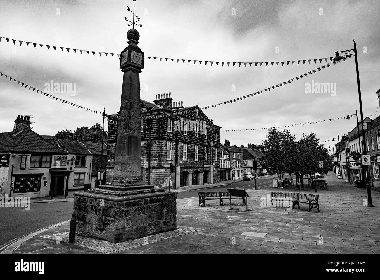Un'immagine in scala di grigi di una croce di mercato nella vecchia città di mercato nel North Yorkshire Foto Stock