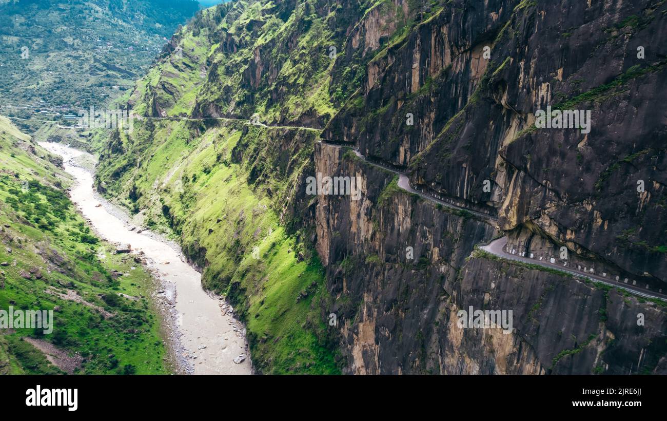 Strada pericolosa e tunnel scavati nelle montagne Himalayan di Tranda Dhank con scogliera e fiume, aereo Foto Stock