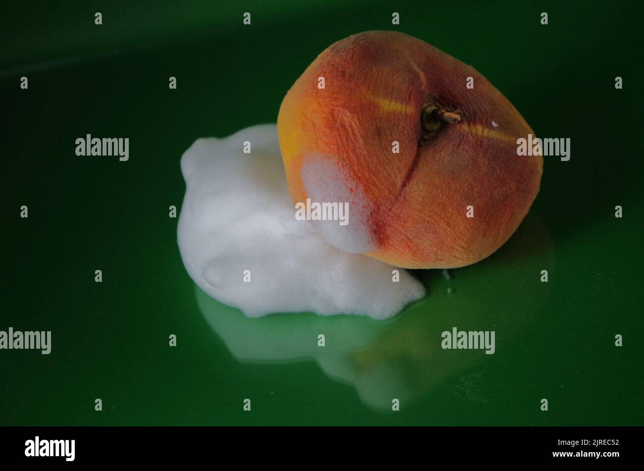 Un Peach con schiuma. Come per cambiare pelle secca in bagnata. Foto Stock