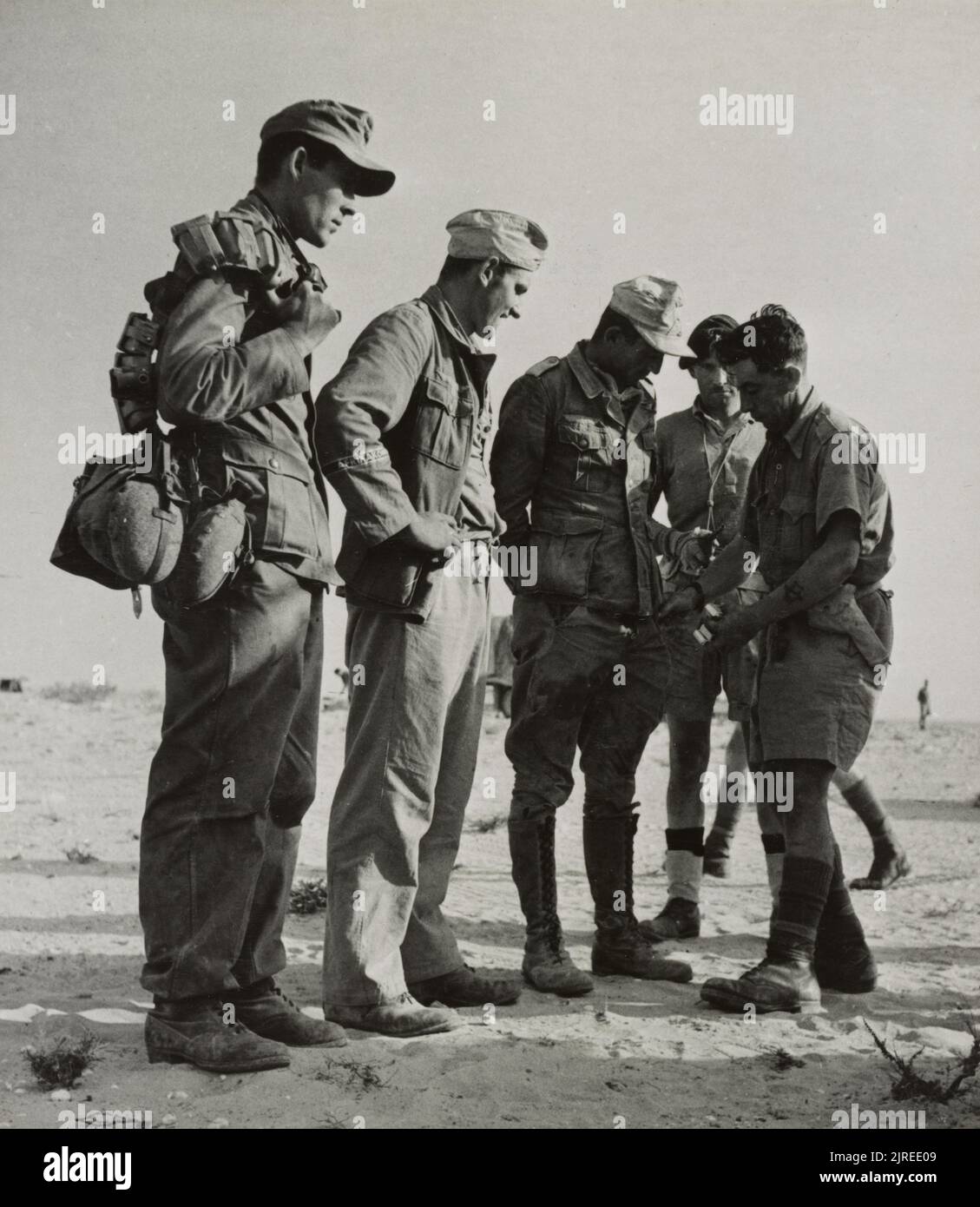 Una foto d'epoca del 1942 che mostra soldati britannici alla ricerca di prigionieri di guerra tedeschi della divisione leggera tedesca Afrika korps 90th dopo essere stato catturato a El Alamein Egitto Foto Stock