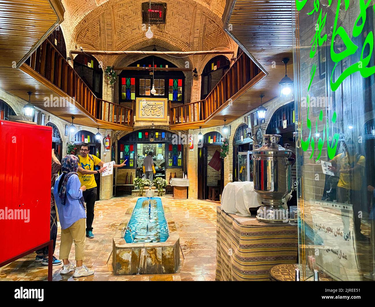 Teheran, Iran - 28th maggio 2022: Guida turistica maschile dell'agenzia Persiana Walk che spiega il gruppo del tour storico nel vecchio edificio storico in un tour a piedi gratuito Foto Stock
