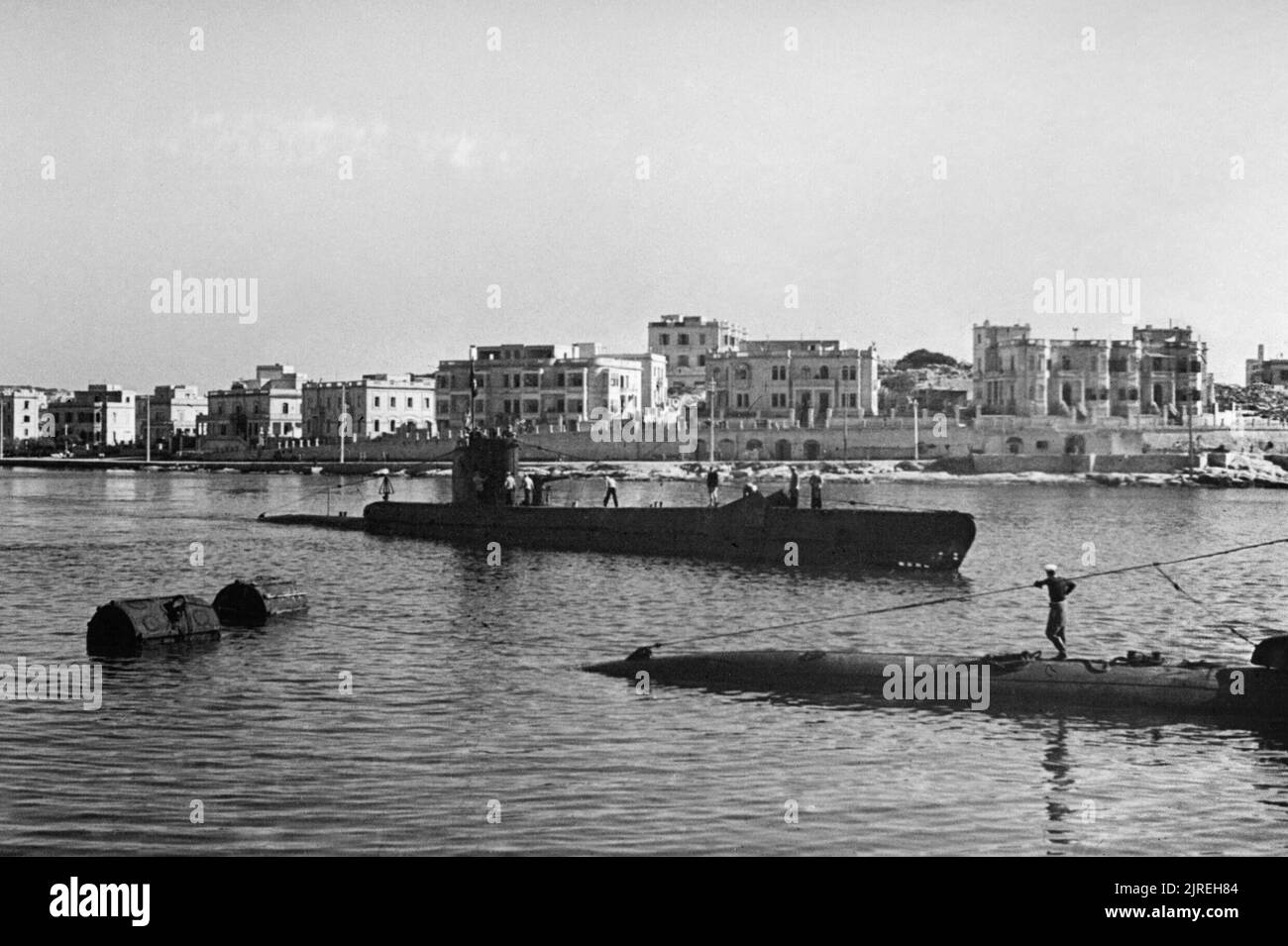 La Royal Navy durante la Seconda Guerra Mondiale l'HMS imperturbabile tornando al porto di Malta dopo una pattuglia nel Mediterraneo dove ha sostenuto le vittorie alleate in Nord Africa, in Sicilia e in Italia. Durante le campagne, la nave della società si sono aggiudicati un DSO e bar, tre DSCs, undici DSMs e sono stati citati in spedizioni in sei occasioni. Il successo sulla sua 'Jolly Roger"indica il naufragio del 12 approvvigionamento di navi per un totale di 40.000 tonnellate, tre golette di alimentazione, la disabilitazione di un incrociatore italiano disabili e un treno girato verso l'alto. Foto Stock