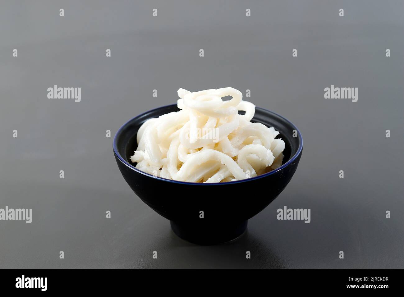 Selezionato Focus Japanese White Udon su ciotola in ceramica, isolato su tavolo grigio Foto Stock