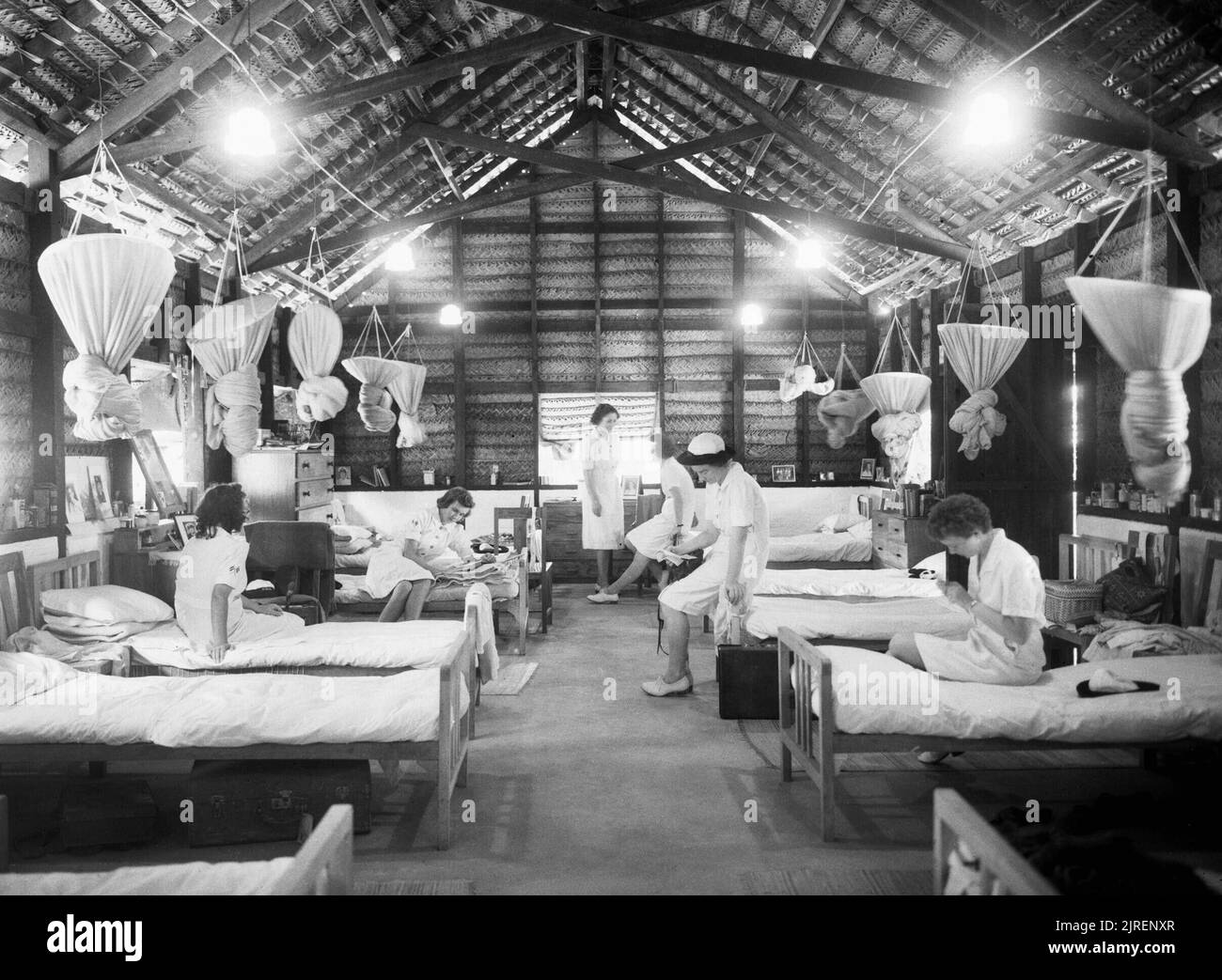 Wrens nel loro 'cajan' cabine con tetto a WRNS trimestri in Ceylon, 1943. Le donne del Royal Naval Service: Wrens coming off guarda trascorrere un soggiorno riposante ora nel loro 'cajan' cabine con tetto a WRNS trimestri in Ceylon. Nota le zanzariere legato e appeso sopra ogni letto. Foto Stock