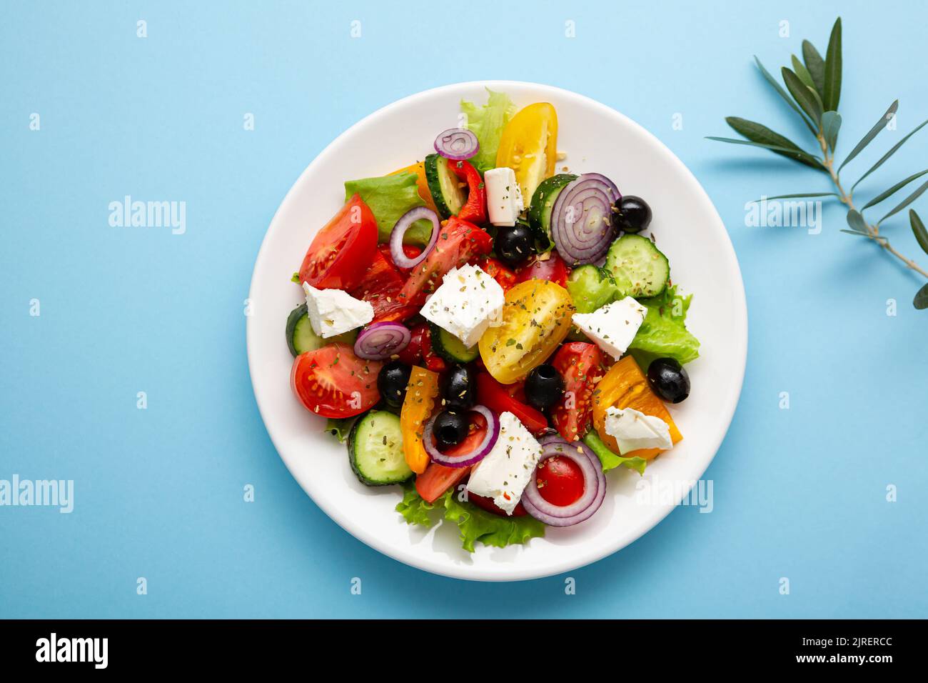 Vista dall'alto di insalata greca fresca o piatto bianco cibo mediterraneo su sfondo blu Foto Stock
