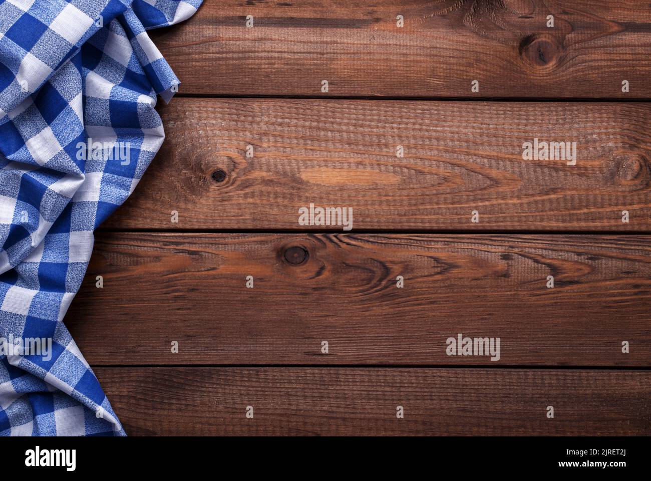 Vecchia tavola in legno d'annata con stoffa da tavolo a scacchi blu, sfondo con spazio per il testo Foto Stock