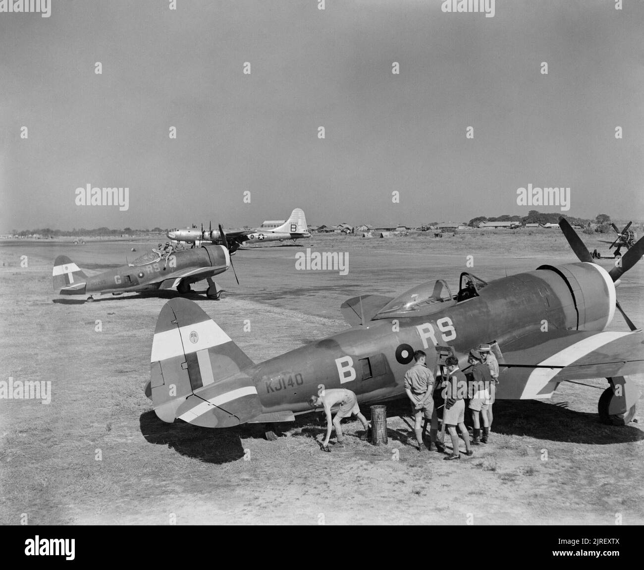 Royal Air Force operazioni in Estremo Oriente, 1941-1945. Due Repubblica marchio Thunderbolt IIs (KJ140 'RS-B' e HD265 'RS-G') di n. 30 Squadron RAF essendo sottoposto a manutenzione Jumchar, India. Nota 30 squadrone di Palm tree badge, che è stata dipinta sul riconoscimento bianco strisce sulla Thunderbolts' code. Parcheggiato dietro di loro è una visita a Boeing B-29 Superfortress del quarantesimo Gruppo di bombardamento, ventesimo USAAF. Foto Stock