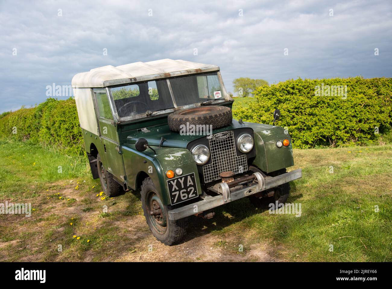 Land Rover Serie uno parcheggiato su una banca erbosa con una siepe dietro in estate nel Derbyshire Foto Stock